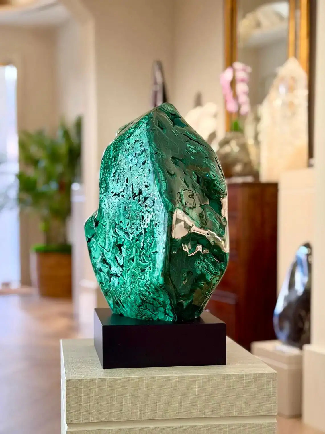 Vibrant emerald-green malachite sculpture with a polished, glossy surface and natural mineral texture.