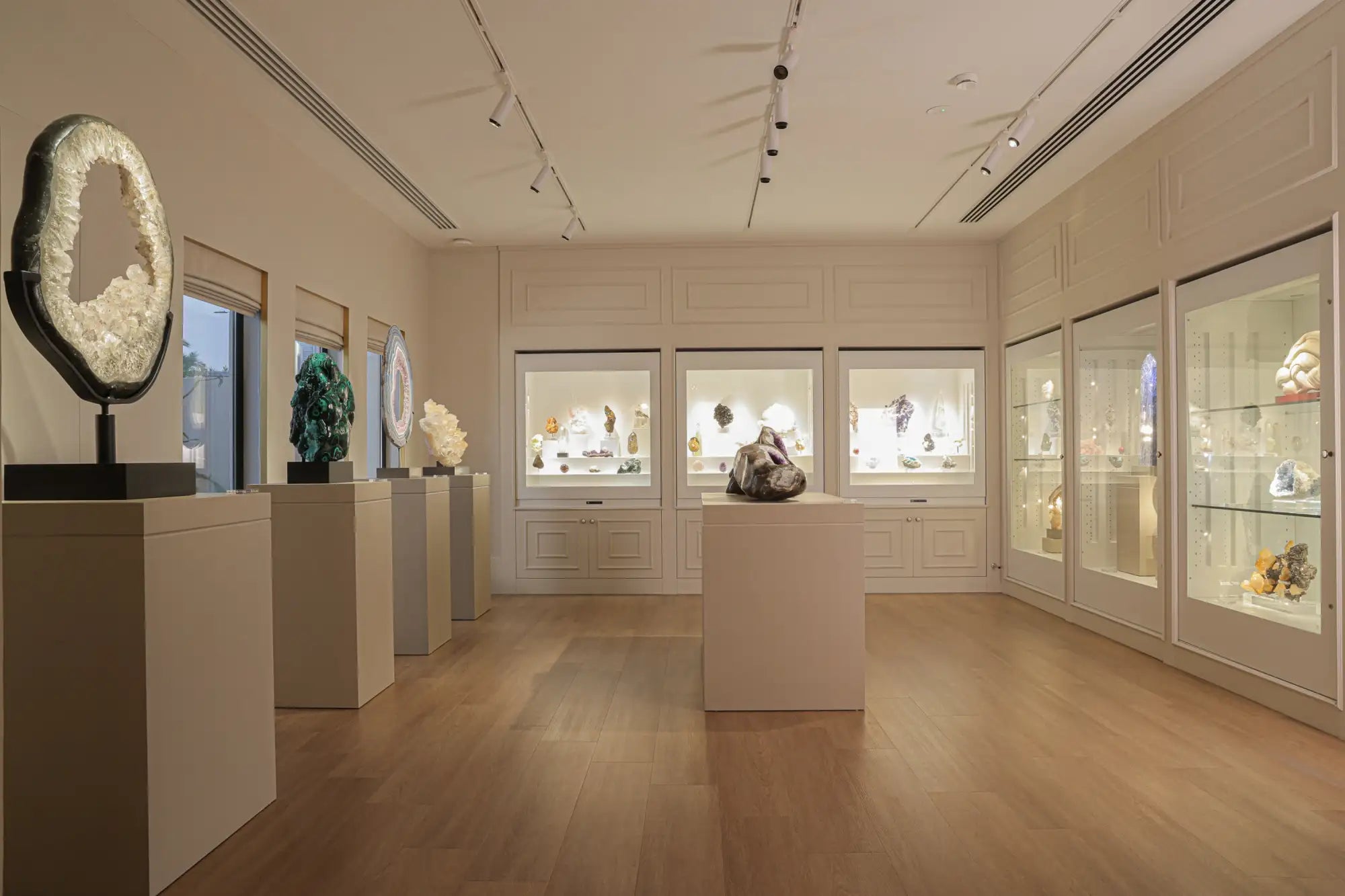 A large, circular geode with a white crystalline interior and dark outer shell displayed on a pedestal.
