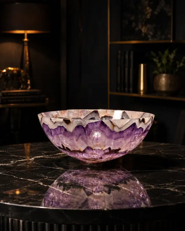 A stunning purple amethyst geode bowl with a natural, jagged rim and translucent layers of deep violet crystal.